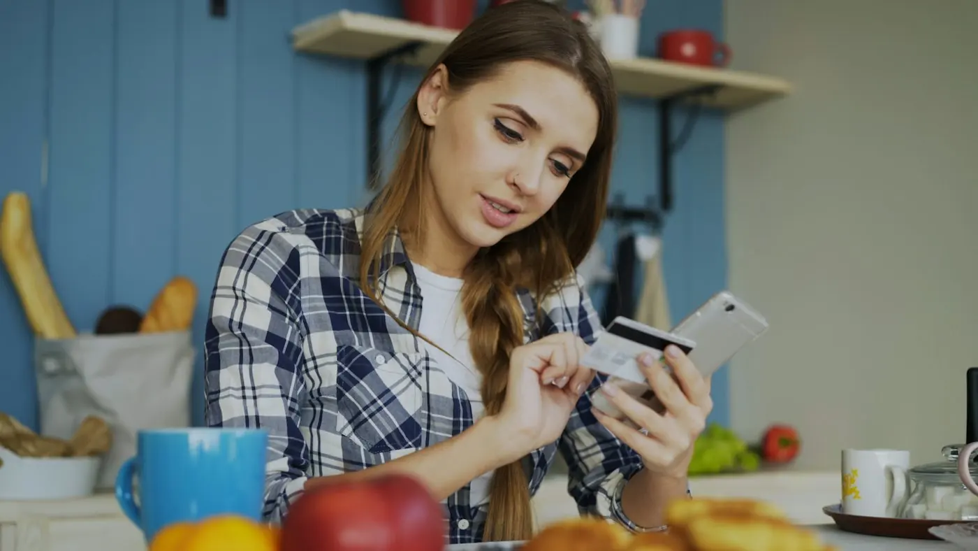 Жінка на кухні з телефоном планує раціон
